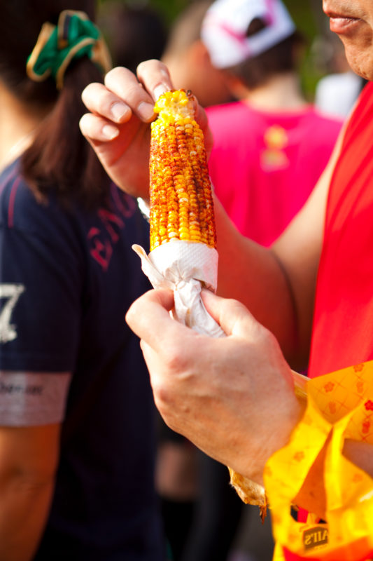Enjoying grilled corn on the cob at Kapiolani Community College Farmers' Market. Photo Credit: Hawaii Tourism Authority