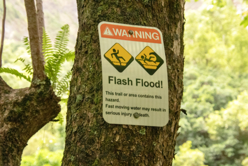 Sign warns of a flash flood area at the Iao Valley State Park in Maui, Hawaii. Editorial credit: Lourdes Venard / Shutterstock.com