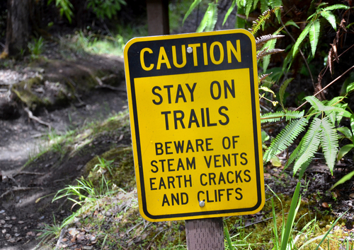 A caution sign near a hiking trail on Kilauea volcano located in Hawaii Volcanoes National Park. Hawaii travel. Things to do in Hawaii.