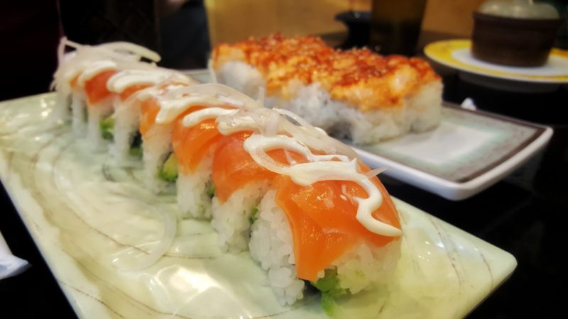 A salmon roll topped with mayo and onions at Kazoku Sushi.