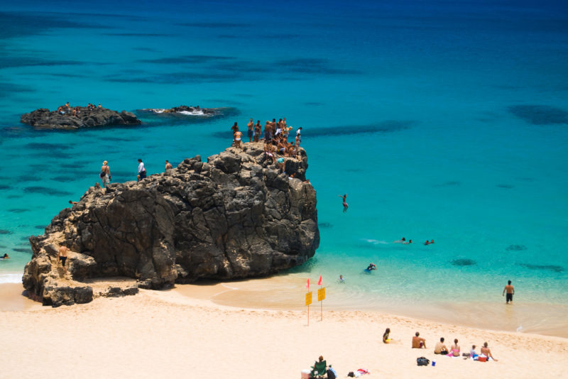 The "jumping rock" at Waimea Bay. The Best Beaches In Oahu’s North Shore For Families.