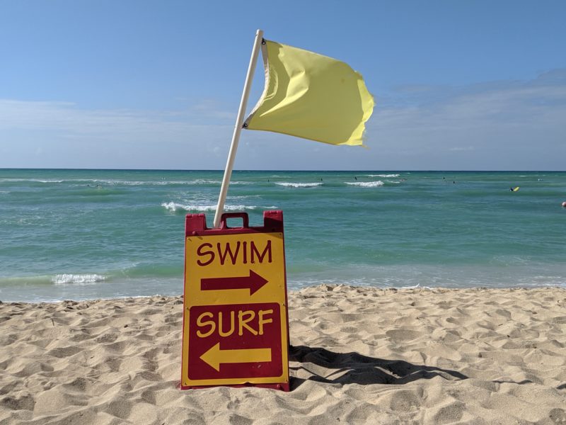 Swim and surf signs in front of the lifeguards at White Plains Beach.