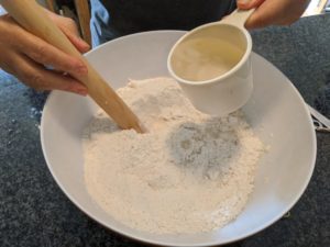 Pour the warm water into the bowl of flour and salt.