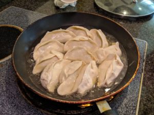 Fill the pan up with water halfway up the jiaozi and cover.