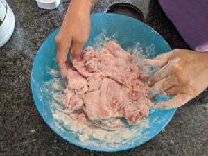 Cover each chicken with flour so that the egg has something to stick to.