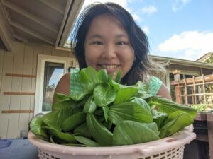 Amy holding a basketful for freshly picked bok choy.
