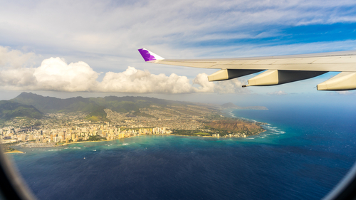 Hawaiian Airlines flight flying over Hawaii with Oahu below.