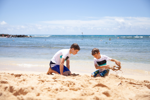 2 kids playing in the sand in Kauai.