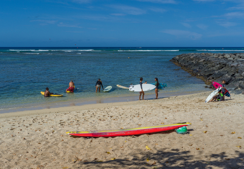 Even in May with its calm waters, surfers can still take to the beach and catch the waves breaking farther out. Editorial credit: Theodore Trimmer / Shutterstock.com