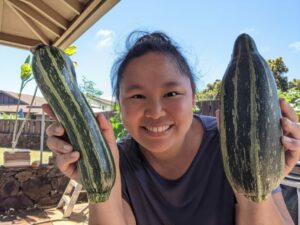 Me holding 2 cocozelle zucchinis. Living in Hawaii & things to do in Hawaii.