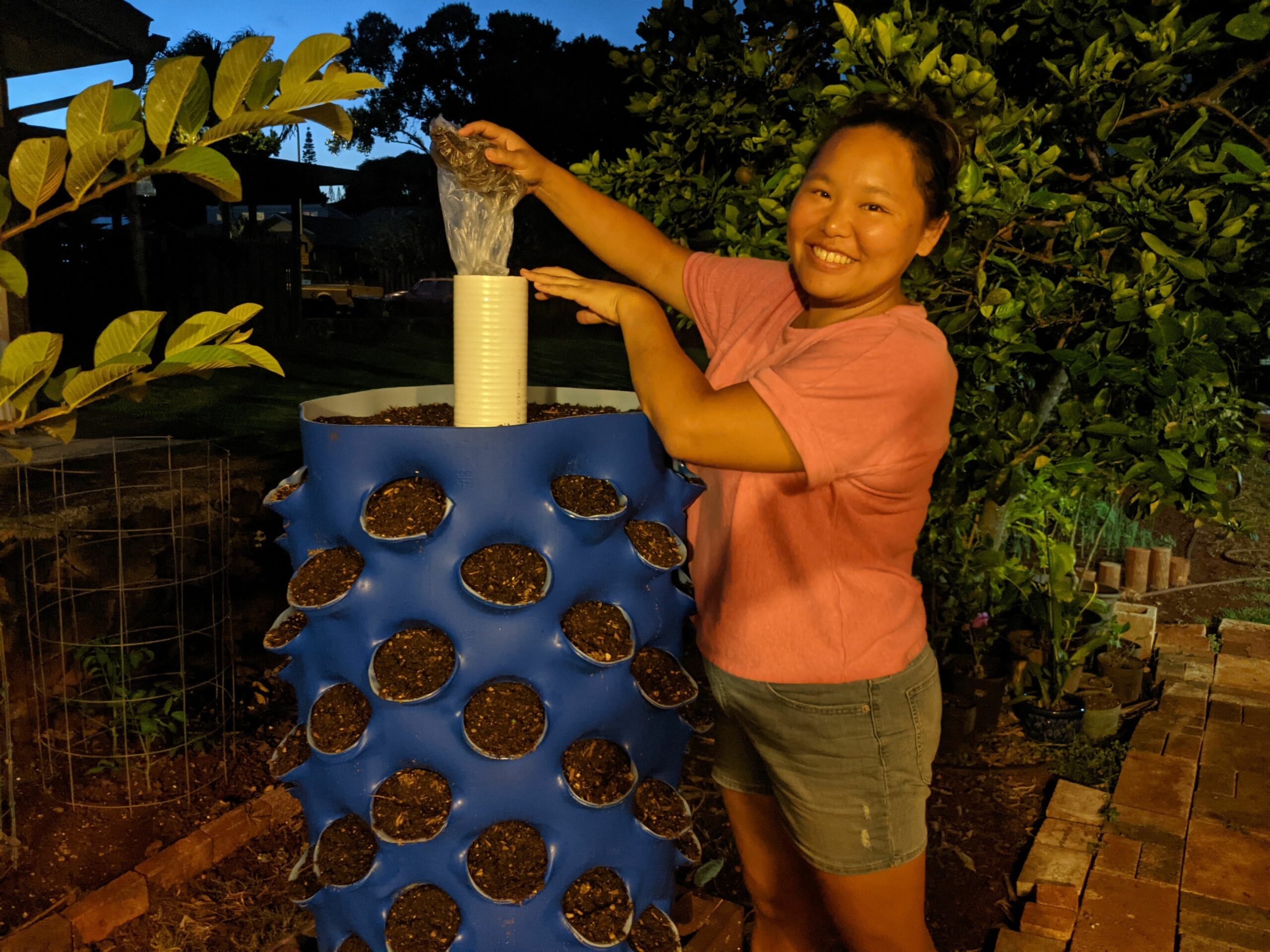Amy with her DIY vertical garden with compost tube.