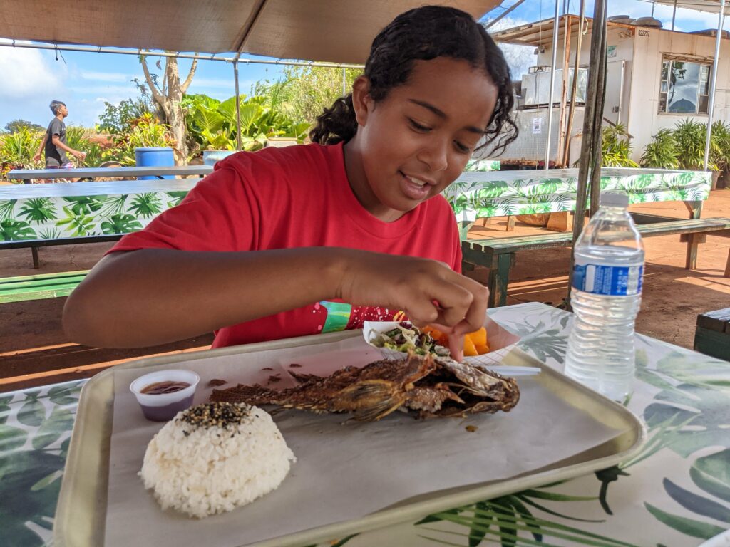 One of the girls enjoying her freshly caught tilapia.