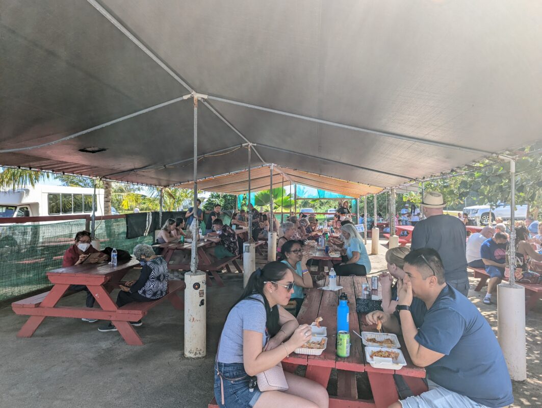 Large tend covering a crowded eating area.