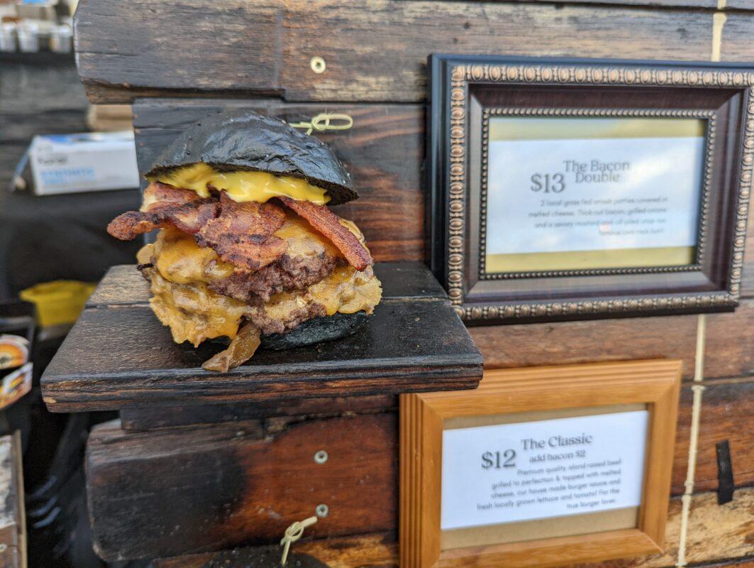 A double patty burger with a black bun.