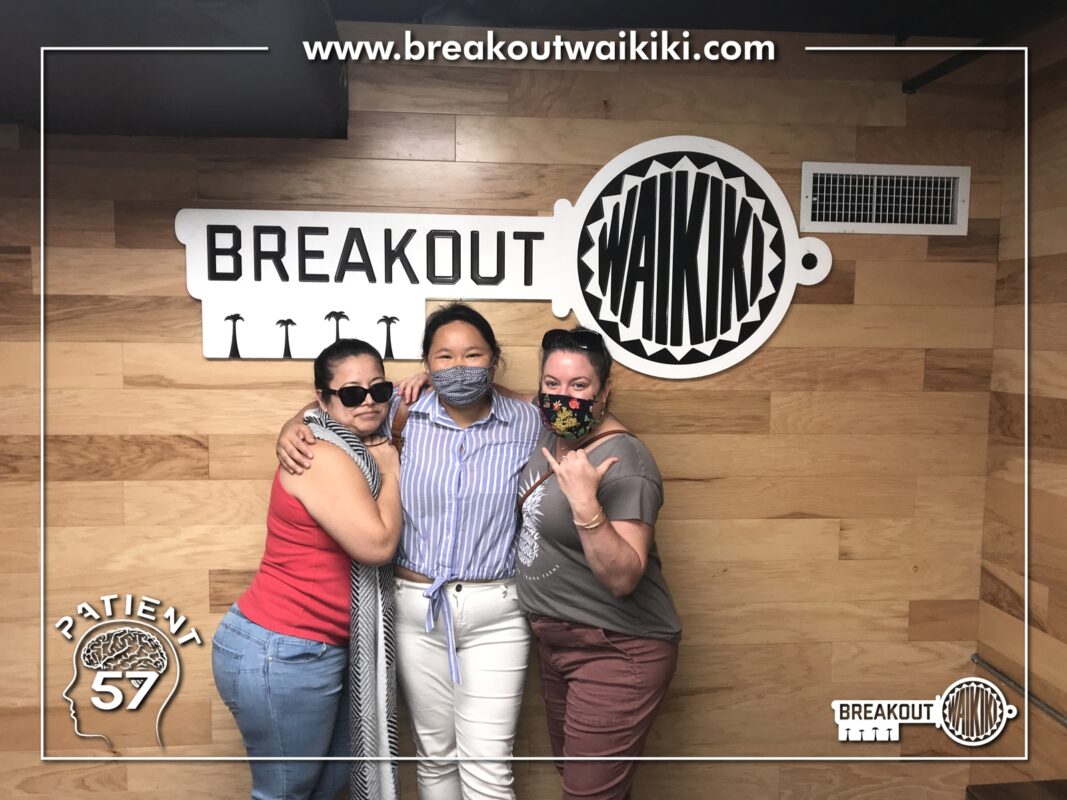 Three women standing in front of Breakout Waikiki sign.